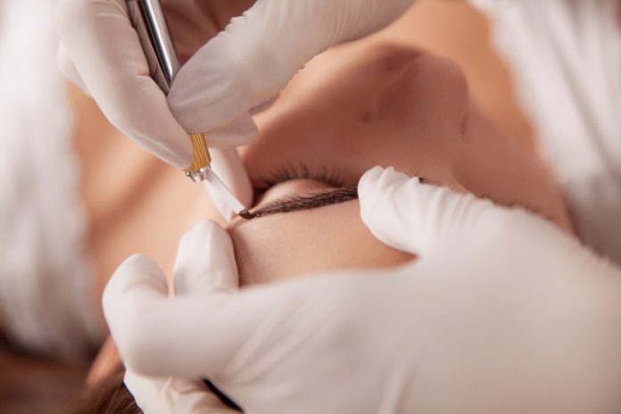 Beautiful woman in beauty slon on eyebrow makeup treatment